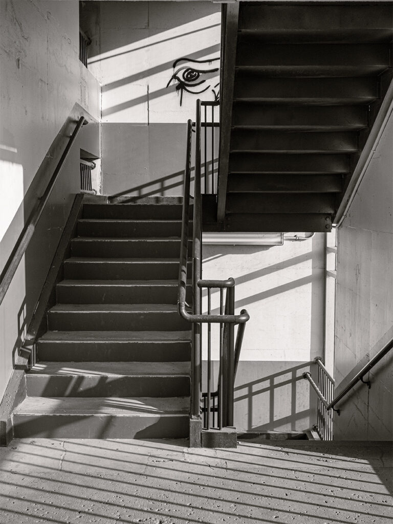 Laurie Schutt • <em>The stairwell is watching</em> • Print on metal • 12″×18″ • $180.00