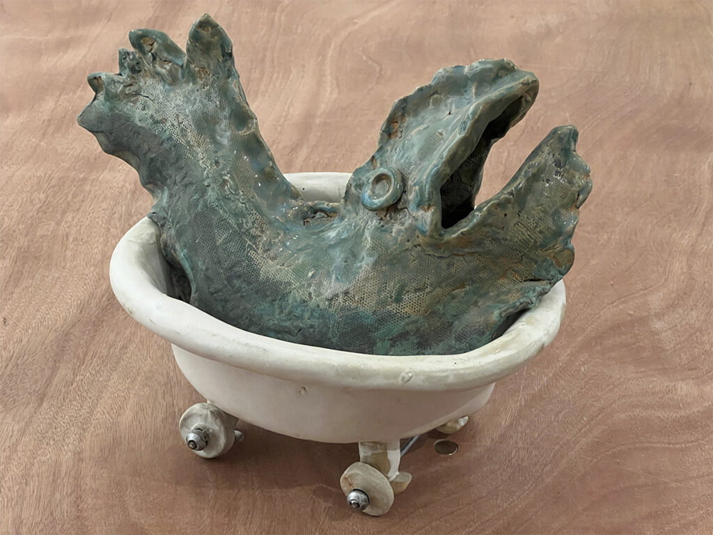 Mary Ann Bowman • <em>Even Though My Ocean Is Small, I Love To Travel</em> • Glazed stoneware with metal easel and rubber hubcap • 12″×9½″×8½″ • $350.00