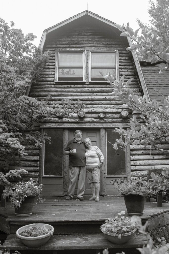 Susan C. Larkin • <em>Dan and Jean by the House that Dan Built</em> • Archival digital print • 18″×24″ • $300.00