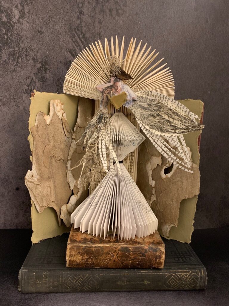 Teresa Yatsko • <em>Reader</em> • Upcycled books, tree bark • 11″× 14″× 7″ • $175.00<a class="purchase" href="https://state-of-the-art-gallery.square.site/product/teresa-yatsko-reader/3497" target="_blank">Buy</a>