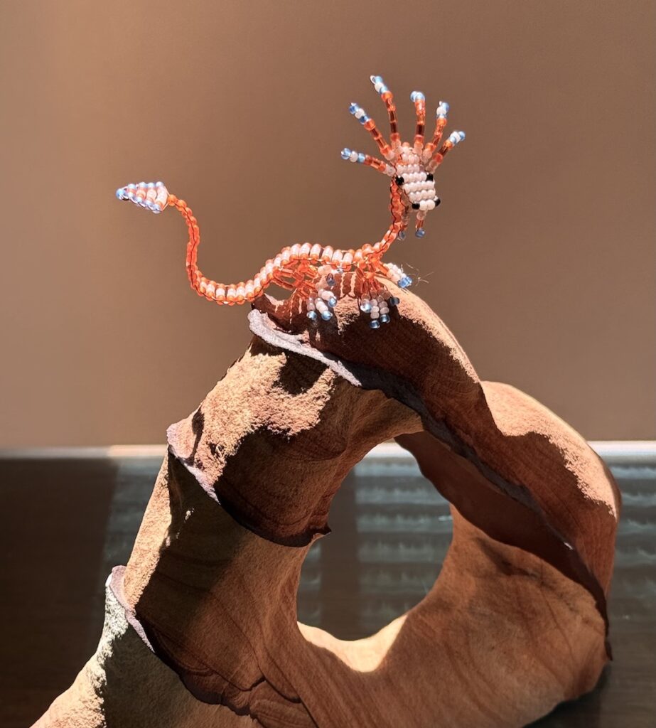 Frances L. Fawcett • <em>Orange Juvenile on his Favorite Perch</em> • Glass beads, wire, stone • 8″× 8″× 3″ • NFS
