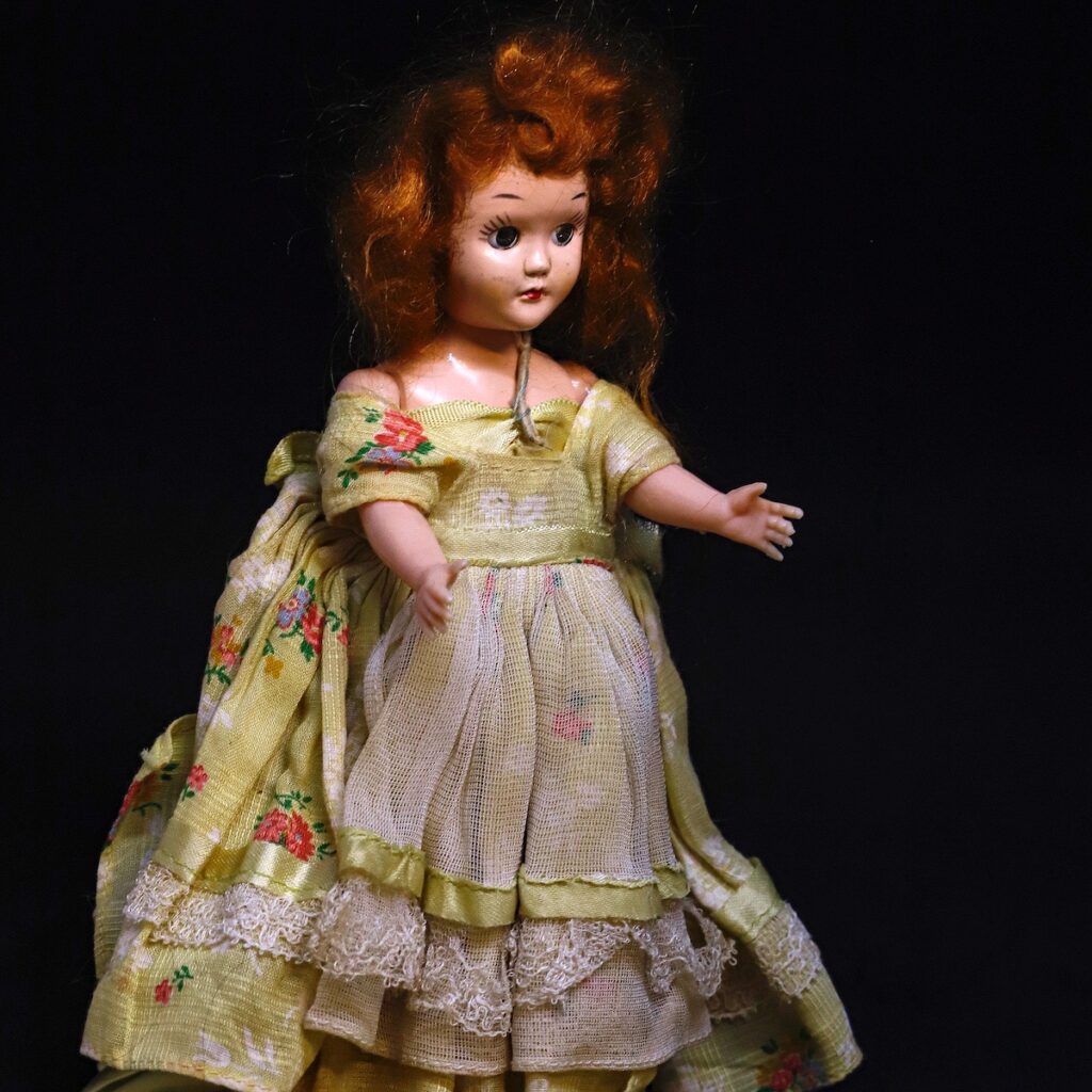 Nancy V. Ridenour • <em>Red Head Doll with Yellow Dress</em> • Digital image on canvas • 8″× 10″ • $45.00