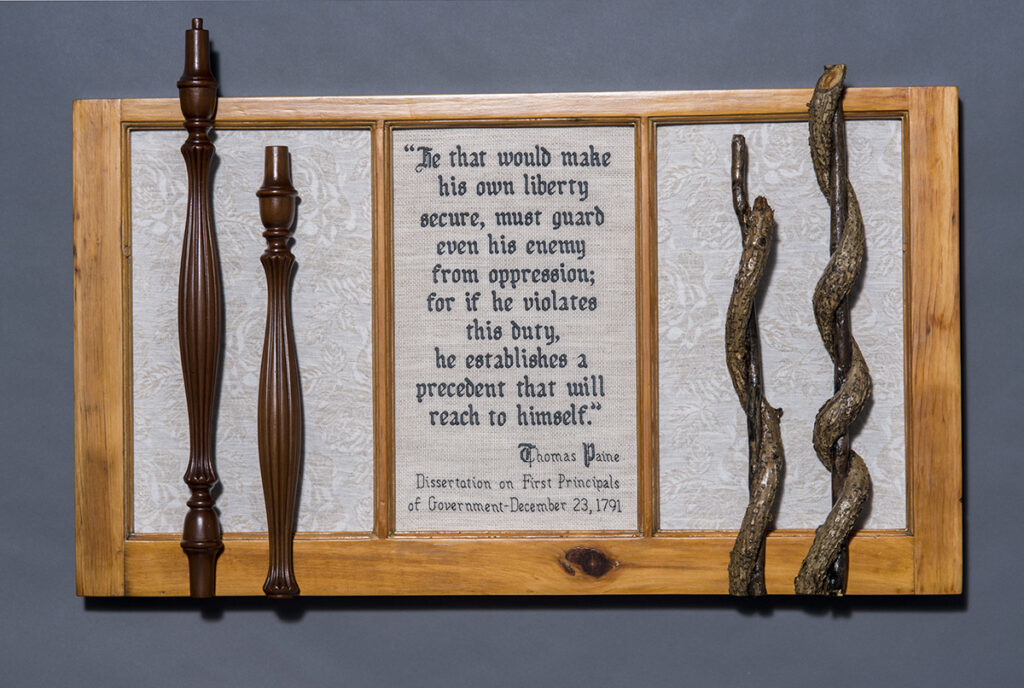 Eva Capobianco&nbsp;• <em>Guard Even Your Enemy</em>&nbsp;• Cross stitch, linen, and found wood&nbsp;• 34″×&nbsp;22″×&nbsp;3″&nbsp;• $475.00